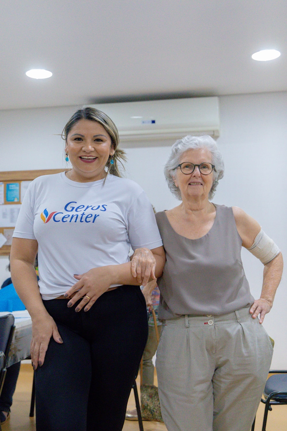Funcionária com senhora abraçadas sorrindo