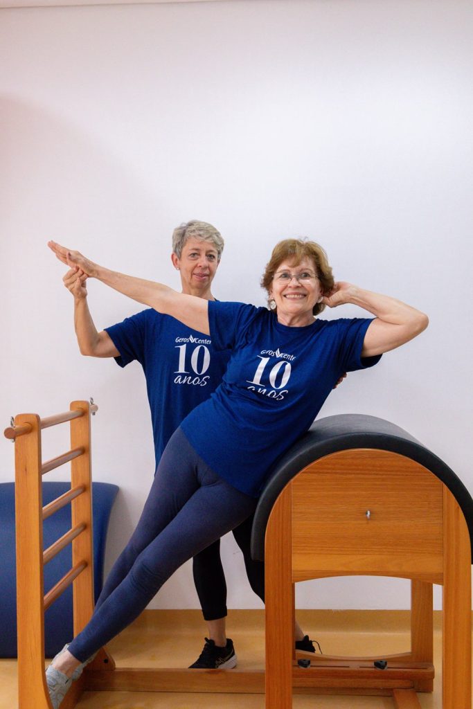 Funcionária com senhora fazendo yoga