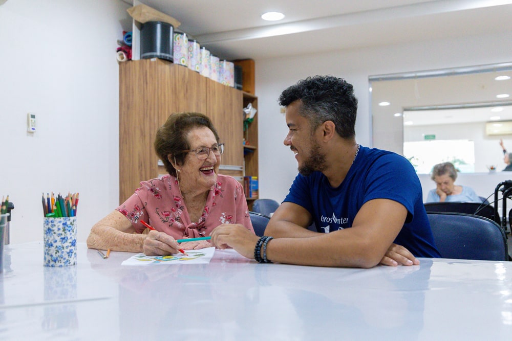 Funcionário com senhora conversando e sorrindo