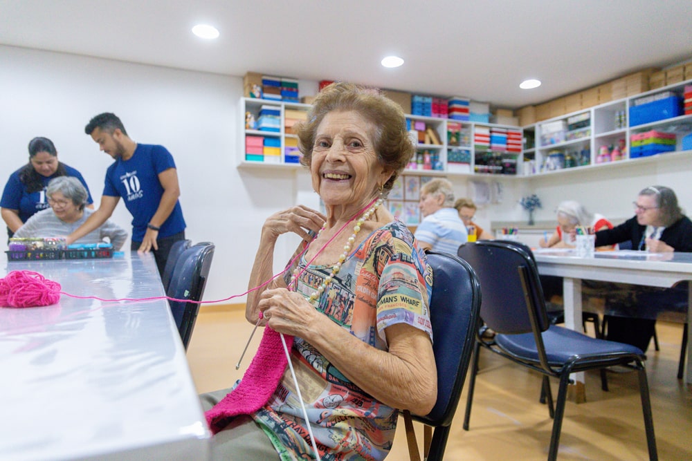 Senhora sorridente com tricô