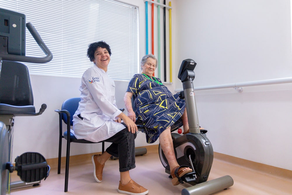 Funcionária e senhora no centro de fisioterapia